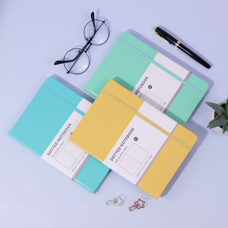 Pastel blue, mint and yellow notebooks arranged on a desk